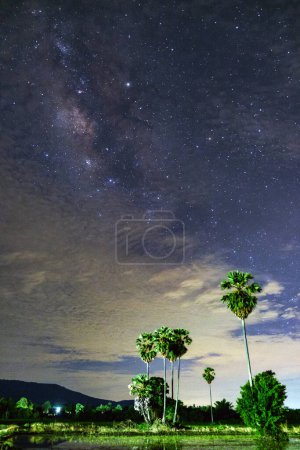 Foto de Vía Láctea con cielo nublado y plam de azúcar, larga exposición fotografía.con grano - Imagen libre de derechos