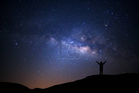 Foto de Paisaje con Vía Láctea, Cielo nocturno con estrellas y silueta de hombre de pie sobre alta montaña - Imagen libre de derechos