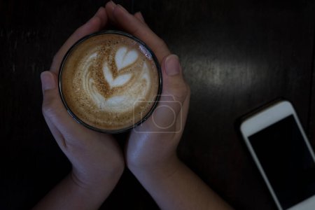 Téléchargez les photos : Femme tenant tasse chaude de café latte - en image libre de droit