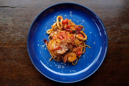 Téléchargez les photos : Sauce tomate spaghetti fruits de mer sur table en bois - en image libre de droit