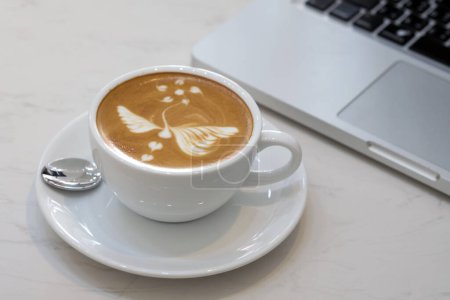 Foto de Café latte arte con ordenador portátil en la cafetería - Imagen libre de derechos
