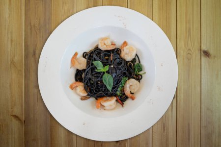 Photo for Black spaghetti with prawns on wooden - Royalty Free Image