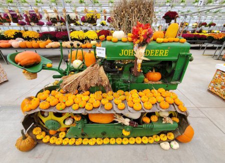 Foto de Quarryville, Pensilvania, Estados Unidos - 19 de octubre de 2023 - Un tractor de jardín John Deer verde decorado con pequeñas calabazas - Imagen libre de derechos