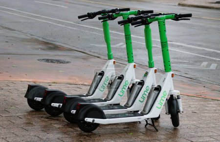 Foto de Austin, Texas, Estados Unidos - 9 de abril de 2024 - Los scooters blancos y verdes de cal disponibles para alquileres a corto plazo en la ciudad - Imagen libre de derechos