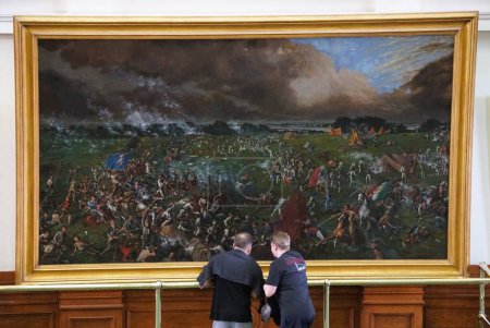 Téléchargez les photos : Austin, Texas, États-Unis - 9 avril 2024 - Visiteurs examinant la peinture de la bataille de San Jacinto de 1895 en face de la salle du Sénat du Capitole du Texas - en image libre de droit