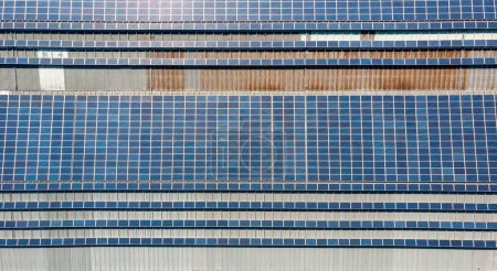 Téléchargez les photos : Vue plongeante de la centrale solaire avec des panneaux placés sur les toits industriels. Production d'énergie durable. - en image libre de droit