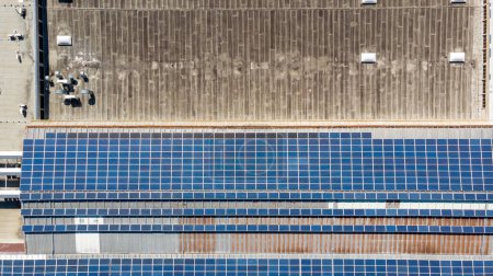 Téléchargez les photos : Vue plongeante de la centrale solaire avec des panneaux placés sur les toits industriels. Production d'énergie durable. - en image libre de droit