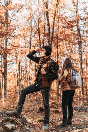 Téléchargez les photos : Jeune couple regardant quelque chose dans les bois. Randonnée, plein air - en image libre de droit