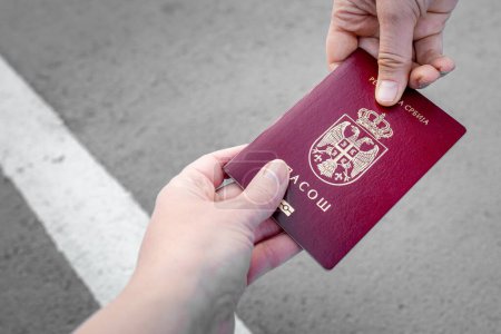 Téléchargez les photos : Remise d'un passeport national de Serbie pour un contrôle à la frontière. Pas de visage, mains - en image libre de droit