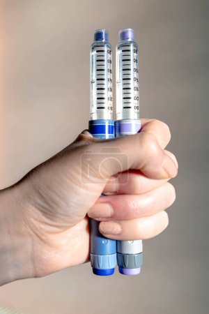 Woman hand holding two insulin pens. Diabetes type one
