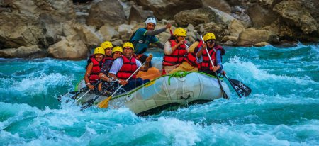 Foto de Young persons rafting on the river Ganges in Rishikesh India, extreme and fun sport at tourist attraction - Imagen libre de derechos