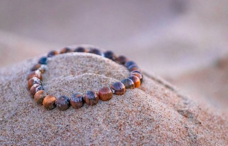 tiger eye crystal on beach sand in Bournemouth, England