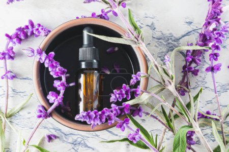 Photo for Top view of essential oil bottle surrounded by lavender leaves and flowers - Royalty Free Image