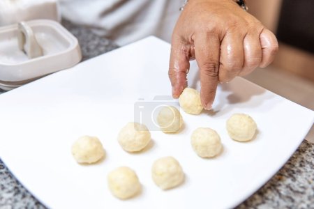 Téléchargez les photos : Womens hands preparing flour balls for the fanesca. High quality photo - en image libre de droit