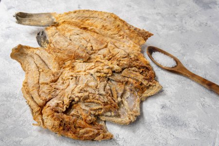 Téléchargez les photos : Cod preserved in salting on a light textured surface and salt - en image libre de droit