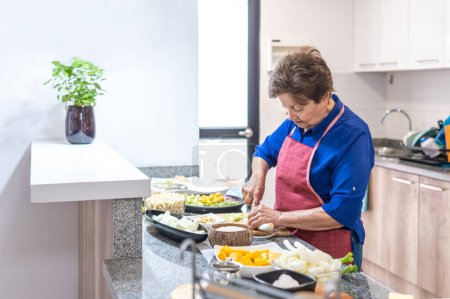 Téléchargez les photos : Old woman cooking in the kitchen. High quality photo - en image libre de droit