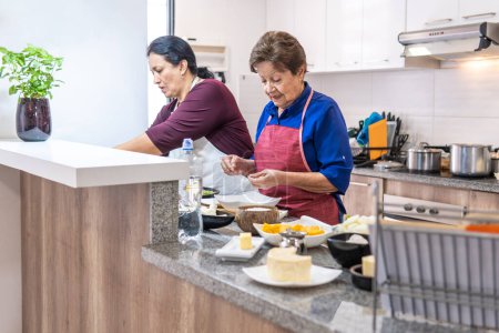 Téléchargez les photos : Deux femmes de différentes générations cuisinent. Photo de haute qualité - en image libre de droit