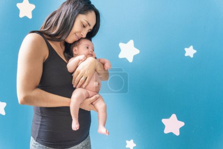 Photo for Young woman lovingly holding her baby who has an umbilical hernia - Royalty Free Image