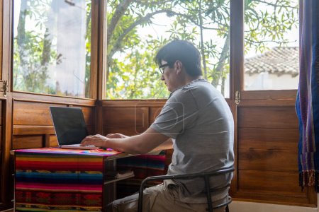 Foto de Nómada digital trabajando en una cabina junto a la ventana escribiendo en un portátil. Foto de alta calidad - Imagen libre de derechos
