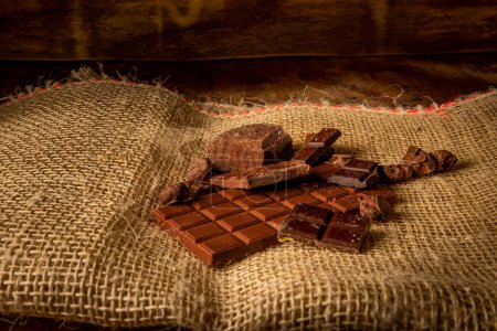 Horizontal photograph of variety of chocolates on rustic background with copy space on a wooden background