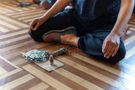 Person in lotus position with lavender and objects for a healing ceremony. High quality photo