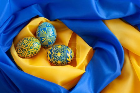 Blaue und gelbe Ostereier auf dem Hintergrund der Flagge der Ukraine
