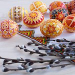 colorful traditional Ukrainian Easter eggs and willow twigs on the background of an embroidered towel and a wooden table