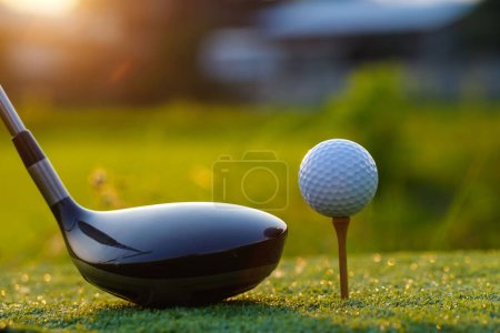 Kije golfowe i piłeczki golfowe na zielonym trawniku w pięknym polu golfowym z porannym słońcem.                                 