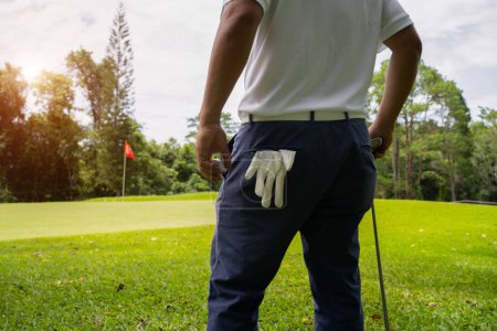 Téléchargez les photos : Homme chemise blanche pantalon bleu Dans la main tenant une balle de golf, préparez-vous à jouer le prochain coup de golf. Sports pratiqués dans le monde entier pendant la quarantaine pour des raisons de santé. - en image libre de droit