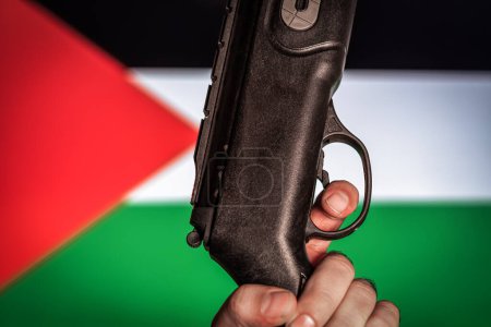 Téléchargez les photos : Israël vs Palestine concept de guerre. Un homme tient une arme. Drapeau palestinien sur fond Concept de guerre - en image libre de droit