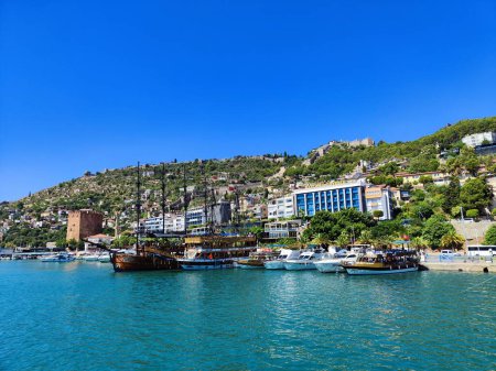 Photo for Bay with boats and clear blue sea with red castle in turkey - Royalty Free Image
