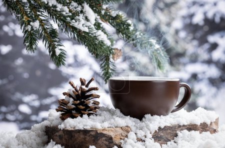 Foto de Bebida caliente de tallo en una taza de café al aire libre en un tocón de árbol con un fondo de invierno nevado - Imagen libre de derechos