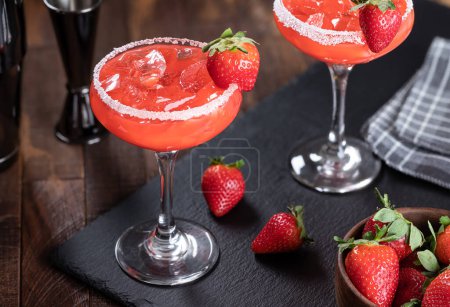 Téléchargez les photos : Cocktail de margarita aux fraises garni de fraises et de sel sur une planche d'ardoise noire - en image libre de droit