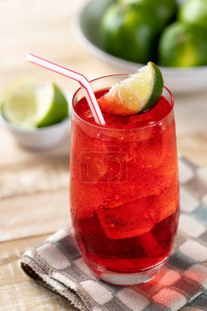 Photo for Cold cherry drink with lime wedges on wooden table - Royalty Free Image