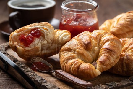 Téléchargez les photos : Croissants aux confitures de fraises et tasse de café sur plateau en bois rustique - en image libre de droit
