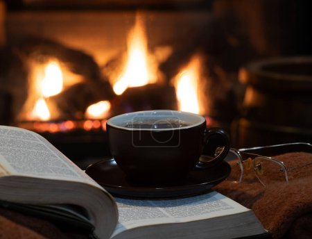 Téléchargez les photos : Tasse de café avec livre ouvert et couverture avec une cheminée en arrière-plan - en image libre de droit
