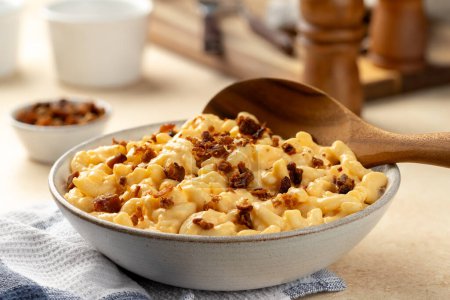 Téléchargez les photos : Macaronis et fromage au bacon dans un bol de service blanc et cuillère en bois - en image libre de droit