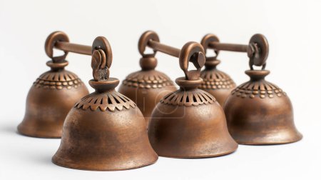 A row of traditional metal bells with intricate designs, on a plain background illustration by generative ai