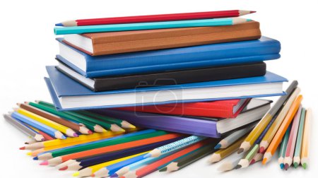 Téléchargez les photos : Empilement de livres colorés avec une dispersion de crayons de couleur autour d'eux sur un fond blanc. - en image libre de droit