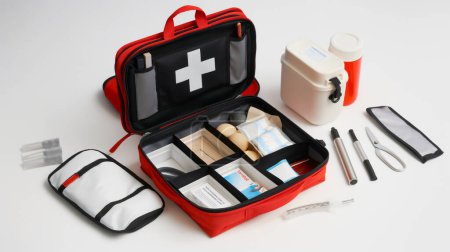 First aid kit open with contents displayed on a white surface.