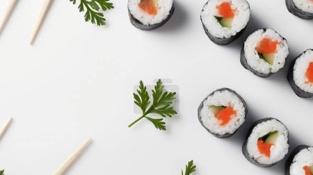 Téléchargez les photos : Rouleaux de sushi au saumon et concombre garnis de persil, bien disposés avec des baguettes sur une surface blanche. - en image libre de droit