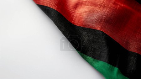 Close-up of a textured flag with red, black, and green colors against a white background.