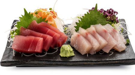 Sortierte Sashimi auf einem schwarzen Schieferteller mit Beilagen, einer japanischen kulinarischen Delikatesse.