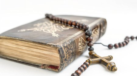 Foto de Un libro antiguo con intrincados diseños de portada y un rosario de madera cubierto. - Imagen libre de derechos