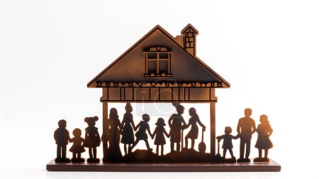 Silhouette einer hölzernen Familie und eines Hauses vor weißem Hintergrund.