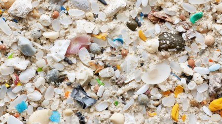 Téléchargez les photos : Gros plan d'un mélange de microplastiques et de sable sur une plage, mettant en lumière les problèmes de pollution. - en image libre de droit