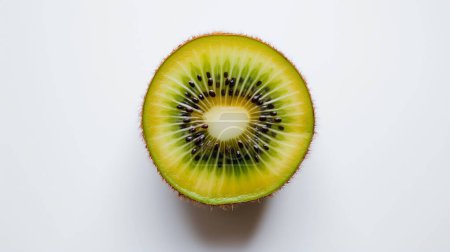 Foto de Una sección transversal vibrante de una fruta kiwi, mostrando su carne verde vívida y semillas negras sobre un fondo blanco. - Imagen libre de derechos