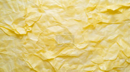 Close-up of a crumpled yellow paper texture, displaying a vibrant and detailed surface with natural light highlighting its contours and creases.