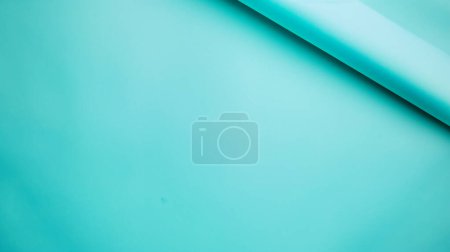 Photo for A simple composition featuring smooth, overlapping sheets of turquoise paper against a matching turquoise background. - Royalty Free Image