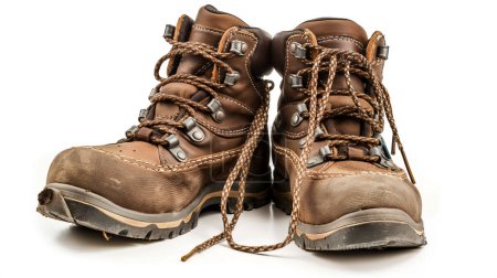 Téléchargez les photos : Worn brown hiking boots with rugged laces and scuffed toes on a white background. - en image libre de droit